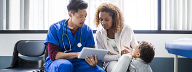 Smiling young family managing healthcare costs on their laptop